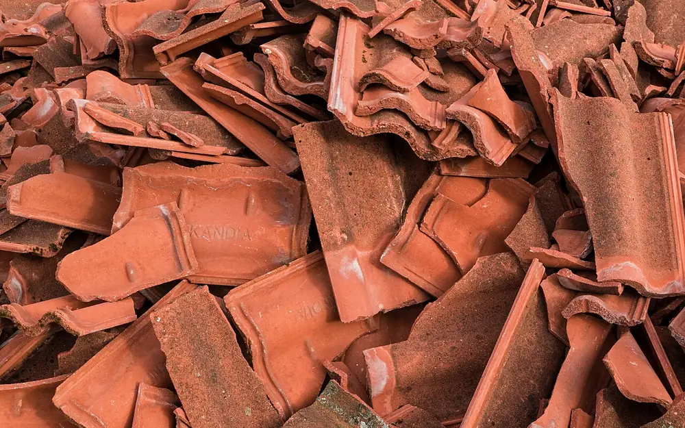 Pile of old broken clay roof tiles after tear off