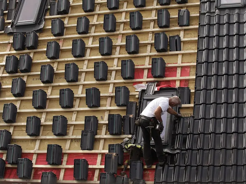 Roofer working on a tiled roof section